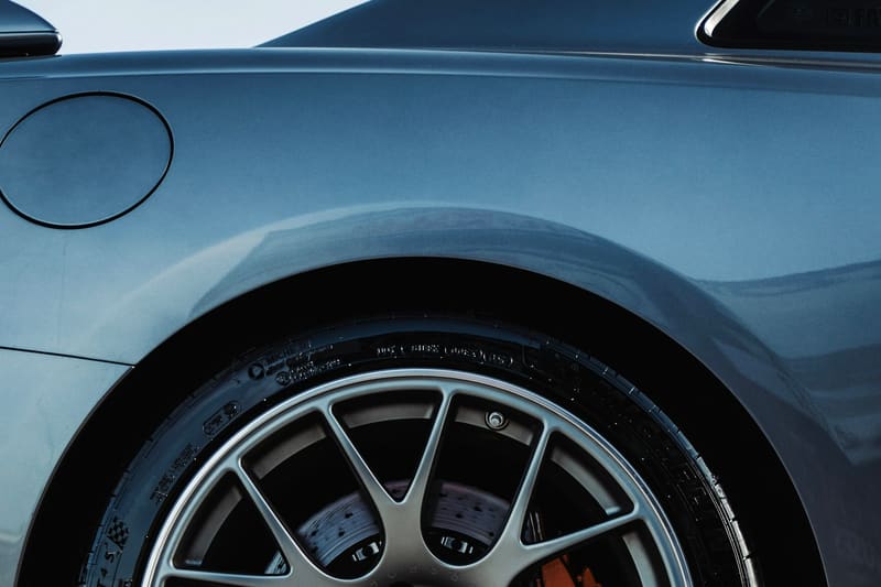 A mesh wheel with an orange caliper behind the spokes.