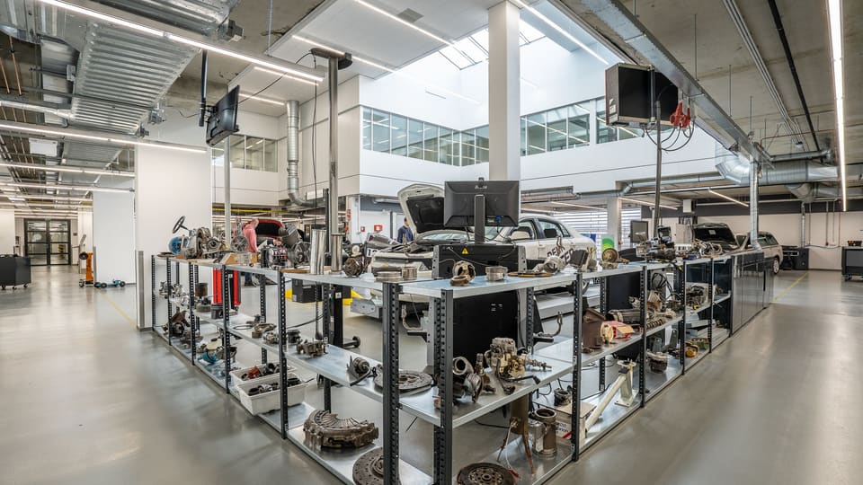 An aisle of racked engine components in a bright, orderly parts store room.