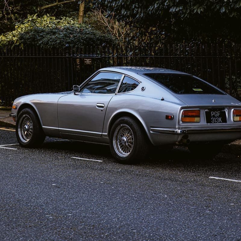 A silver coupe photographed from the rear three-quarter in daylight.